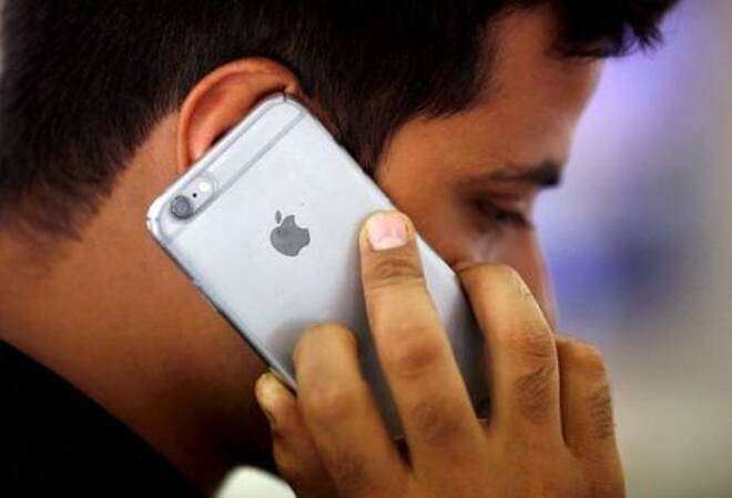 FOTO DE ARCHIVO: Un hombre habla por su iPhone en una tienda de teléfonos móviles en Nueva Delhi.