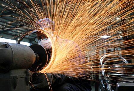 Un trabajador con trabaja en una línea de producción fabricando llantas de acero para bicicletas en una fábrica en Hangzhou