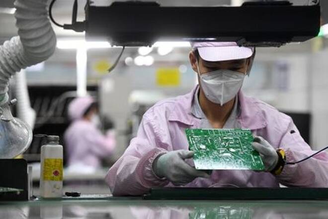 FOTO DE ARCHIVO: Una empleada inspecciona un circuito impreso en una cadena de producción en Wuhan