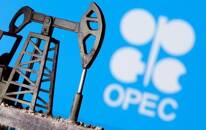 Foto de archivo ilustrativa del logo de la OPEP junto a una impresión 3D de un balancín de petróleo