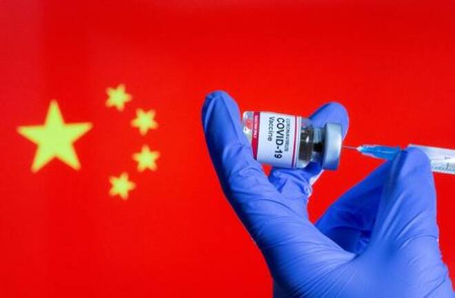 Ilustración fotográfica que muestra a una enfermera extrayendo una dosis de un vial de vacuna contra el coronavirus, con una bandera de China de fondo.