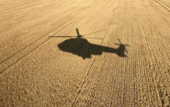 La sombra de un helicóptero del Servicio de Emergencia Estatal de Ucrania se proyecta en un campo de trigo, en Ucrania
