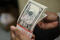 Imagen de archivo de un fajo de billetes de 5 dólares siendo revisado por un empleado de la Oficina de Grabado e Impresión en Washington, EEUU.