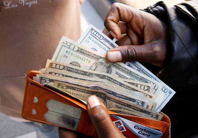 FOTO DE ARCHIVO: Un hombre muestra billetes de dólares estadounidenses después de retirar efectivo de un banco en Harare