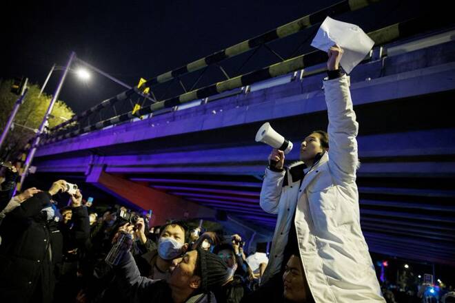 FOTO DE ARCHIVO. Una persona sostiene hojas de papel blancas en protesta por las restricciones a la enfermedad del coronavirus (COVID-19) tras una vigilia por las víctimas de un incendio en Urumqi, mientras continúan los brotes de COVID-19, en Pekín, China