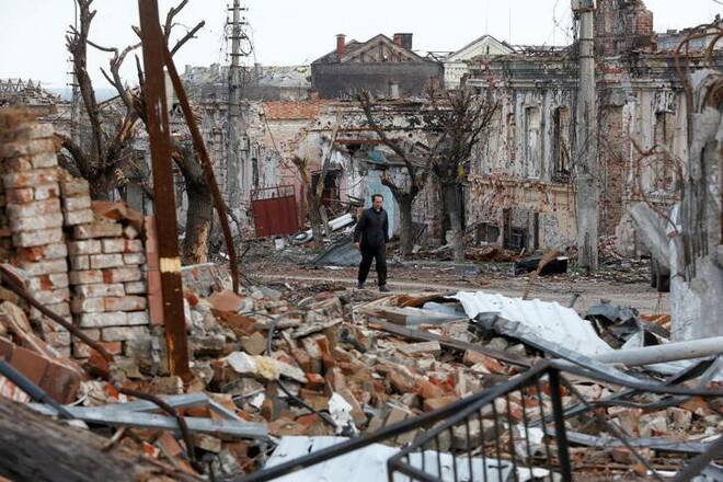 Foto de archivo de un hombre caminando en medio de edificios destruidos en Mariupol