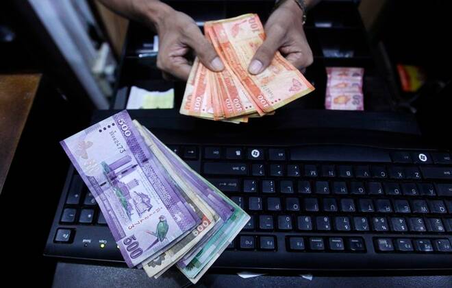 FOTO DE ARCHIVO: Un vendedor prepara billetes de rupias ceilandesas en Colombo