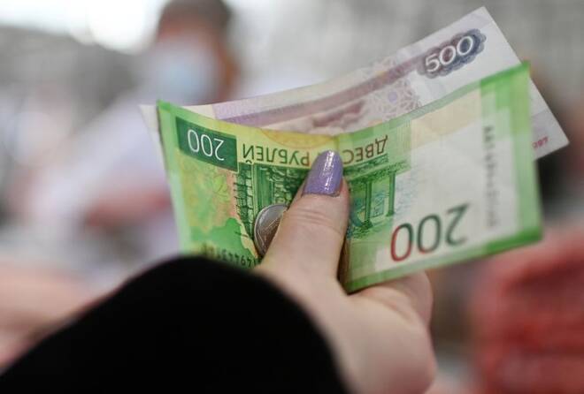 Un cliente entrega billetes y monedas de rublo ruso a un vendedor en un mercado de Omsk