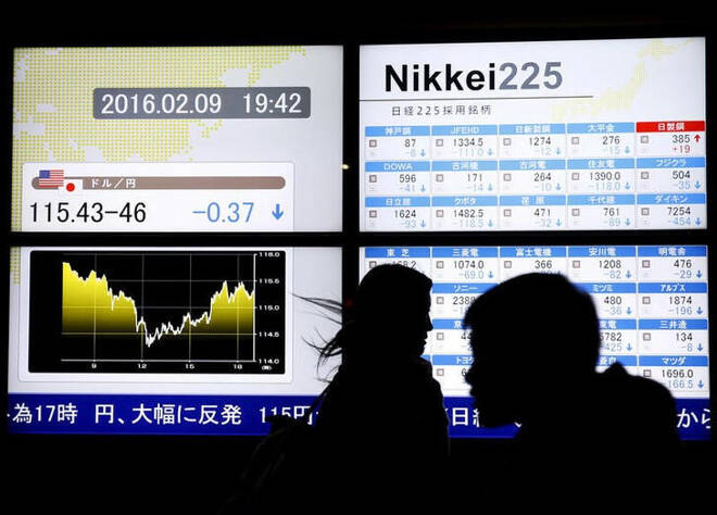 Imagen de archivo de personas pasando frente a pantallas electrónicas con gráficos bursátiles al exterior de una correduría en Tokio, Japón.