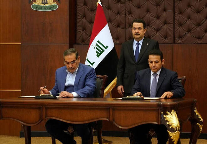 El primer ministro iraquí, Mohammed Shia al-Sudani (detrás), mira mientras el secretario del Consejo Supremo de Seguridad Nacional iraní, Ali Shamkhani, y el asesor de Seguridad Nacional iraquí, Qasim al-Araji, firman un acuerdo de seguridad en Bagdad, Irak.