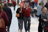 Dos pensionistas caminan por una calle de Ronda