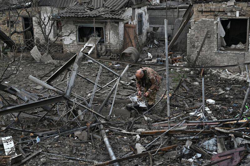 Un oficial de policía inspecciona los restos de un misil ruso que impactó en una zona residencial, en medio del ataque de Rusia a Ucrania, en Zaporiyia