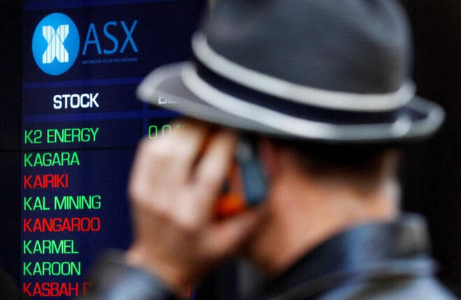 Imagen de archivo de una persona hablando por celular frente a una pantalla electrónica con información bursátil en la Bolsa de Australia en Sídney.