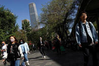 Varias personas caminan por el distrito central de negocios durante la hora punta en Pekín, China.