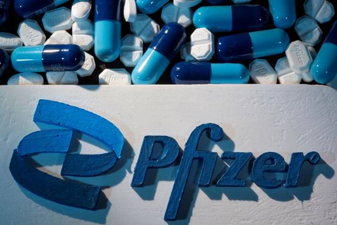 Il logo Pfizer accanto a numerose pillole