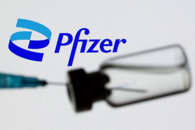 Il logo Pfizer dietro a una fiala