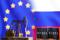 Miniature di una pompa petrolifera e di barili di greggio davanti alle bandiere dell'Unione europea e della Russia