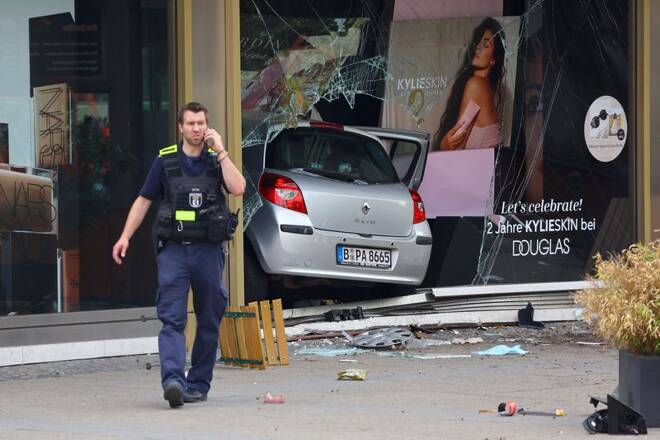 Un poliziotto davanti a una vetrina sfondata da un'auto a Berlino