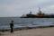 Un uomo sulla spiaggia davanti al porto di Berdyansk sul Mar Azov