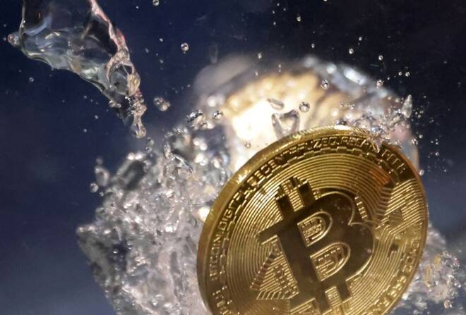 Una rappresentazione fisica di un Bitcoin che affonda in acqua