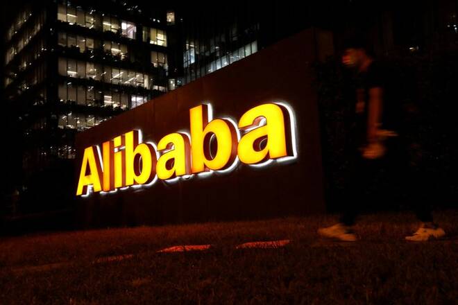 Un uomo passa davanti a un logo di Alibaba Group nel suo edificio di uffici a Pechino