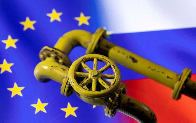 Un modellino di un gasdotto di fronte alle bandiere di Russia e Unione europea