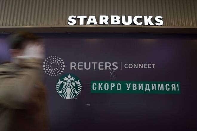Un uomo passa davanti ad uno Starbucks café chiuso a San Pietroburgo