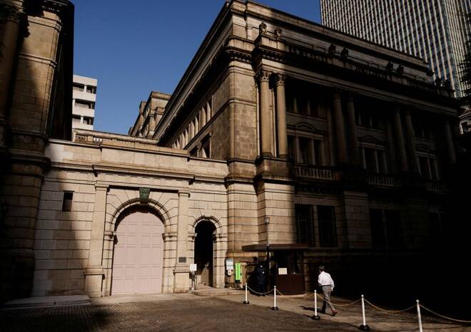Un uomo cammina presso la sede della Bank of Japan a Tokyo