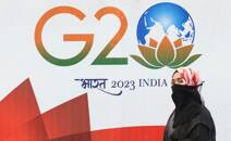 Una donna davanti il logo del G20 di India a Mumbai