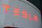 Il logo Tesla presso una stazione di ricarica
