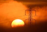 Il sole tramonta dietro un traliccio dell'elettricità, vicino a Petersfield, Gran Bretagna
