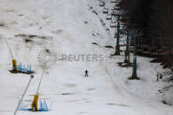 Uno sciatore scia su una pista coperta di neve artificiale sul Monte Cimone