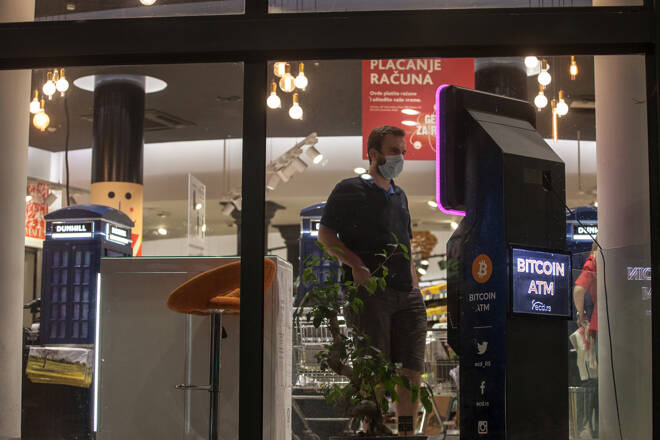 Man in Geschäft mit Bitcoin-Automat