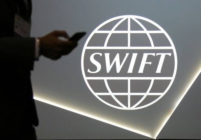ARHCIV: Ein Mann mit einem Mobiltelefon am Logo der globalen Genossenschaft für sichere Finanznachrichtendienste SWIFT auf der Banken- und Finanzkonferenz SIBOS in Toronto, Kanada.