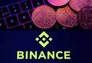 ARCHIV: Binance-Logo und Darstellung von Kryptowährungen