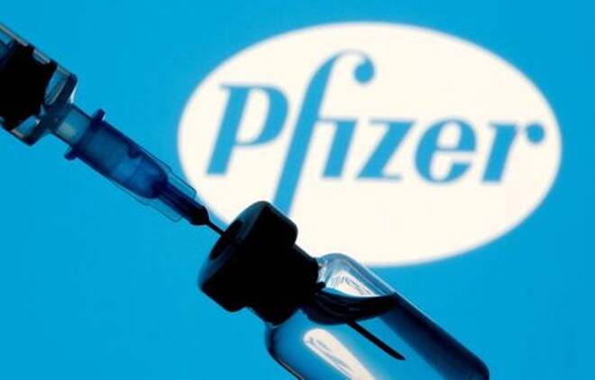 Impfstoff-Ampulle und Spritze vor dem Pfizer-Logo, 11. Januar 2021.