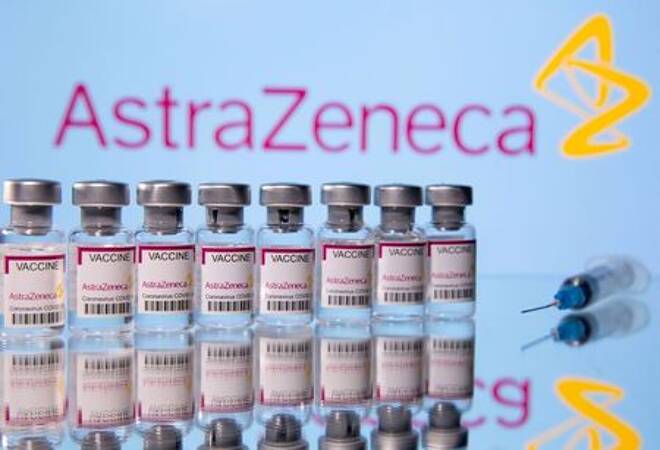 Fläschchen mit Impfstoffetiketten von AstraZeneca und eine Spritze in