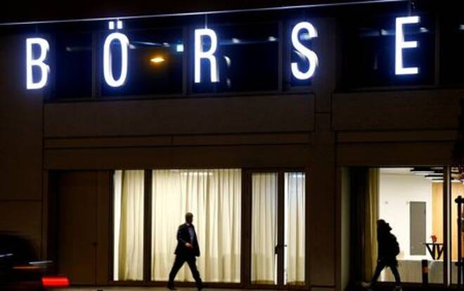 A man walks under the illuminated word "Borse"